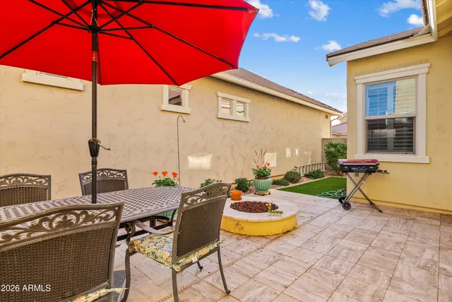 a view of a patio with table and chairs under an umbrella