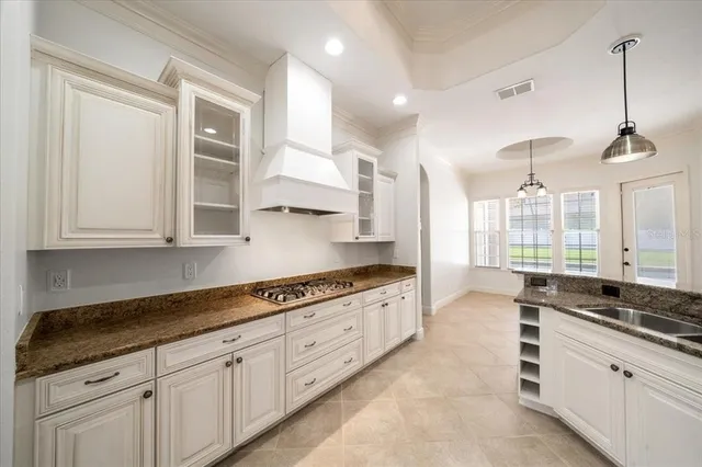 a view of an empty room with a chandelier fan and a window