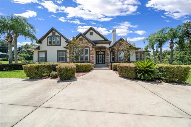 a front view of a house with a yard and potted plants