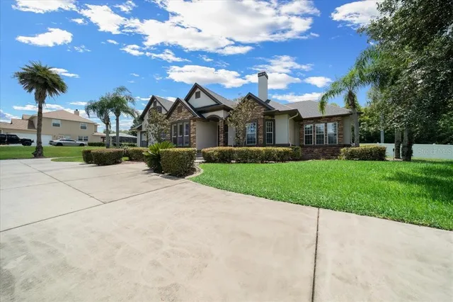 a view of a livingroom with a chandelier fan and windows