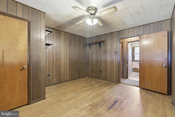 a view of an empty room with a chandelier fan