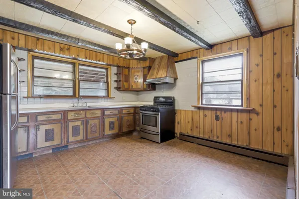 a large kitchen with stainless steel appliances granite countertop a stove and cabinets