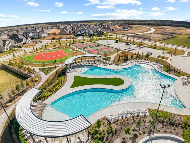 an aerial view of a swimming pool with a patio and lake view