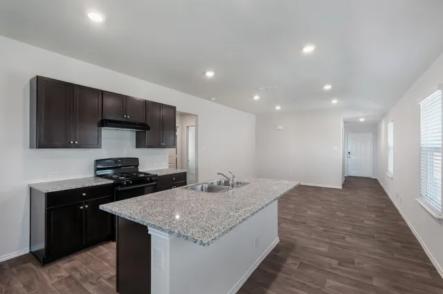 a kitchen with sink cabinets and stove top oven