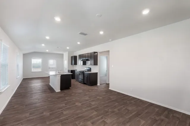 a view of kitchen with a sink and dishwasher a oven with wooden floor