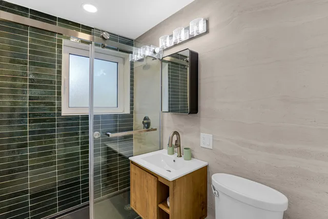 a bathroom with a sink toilet vanity and mirror