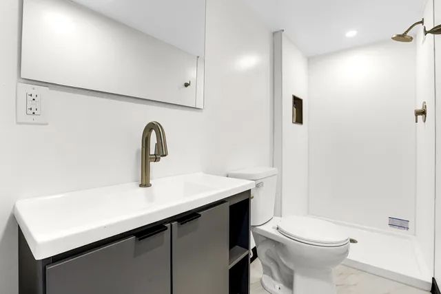 a bathroom with a sink a toilet and shower