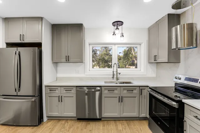 a kitchen with stainless steel appliances a sink stove and refrigerator