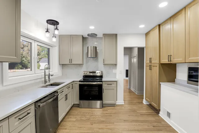 a kitchen with stainless steel appliances granite countertop a sink stove and refrigerator