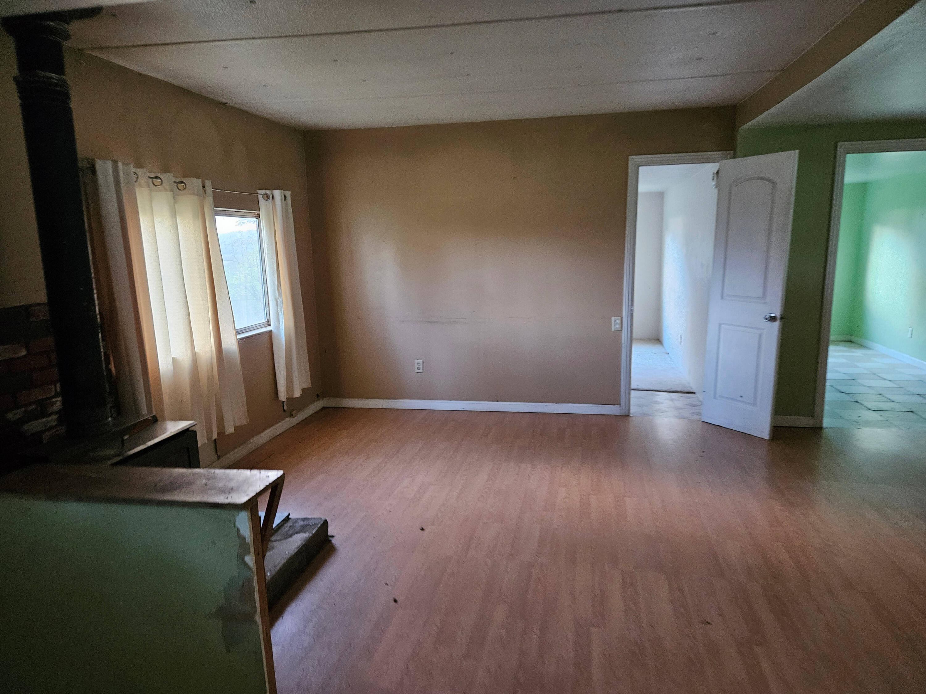 21675 Wildcat Road Shingletown, CA 96088 - Photo 36 of 65 an empty room with wooden floor and windows