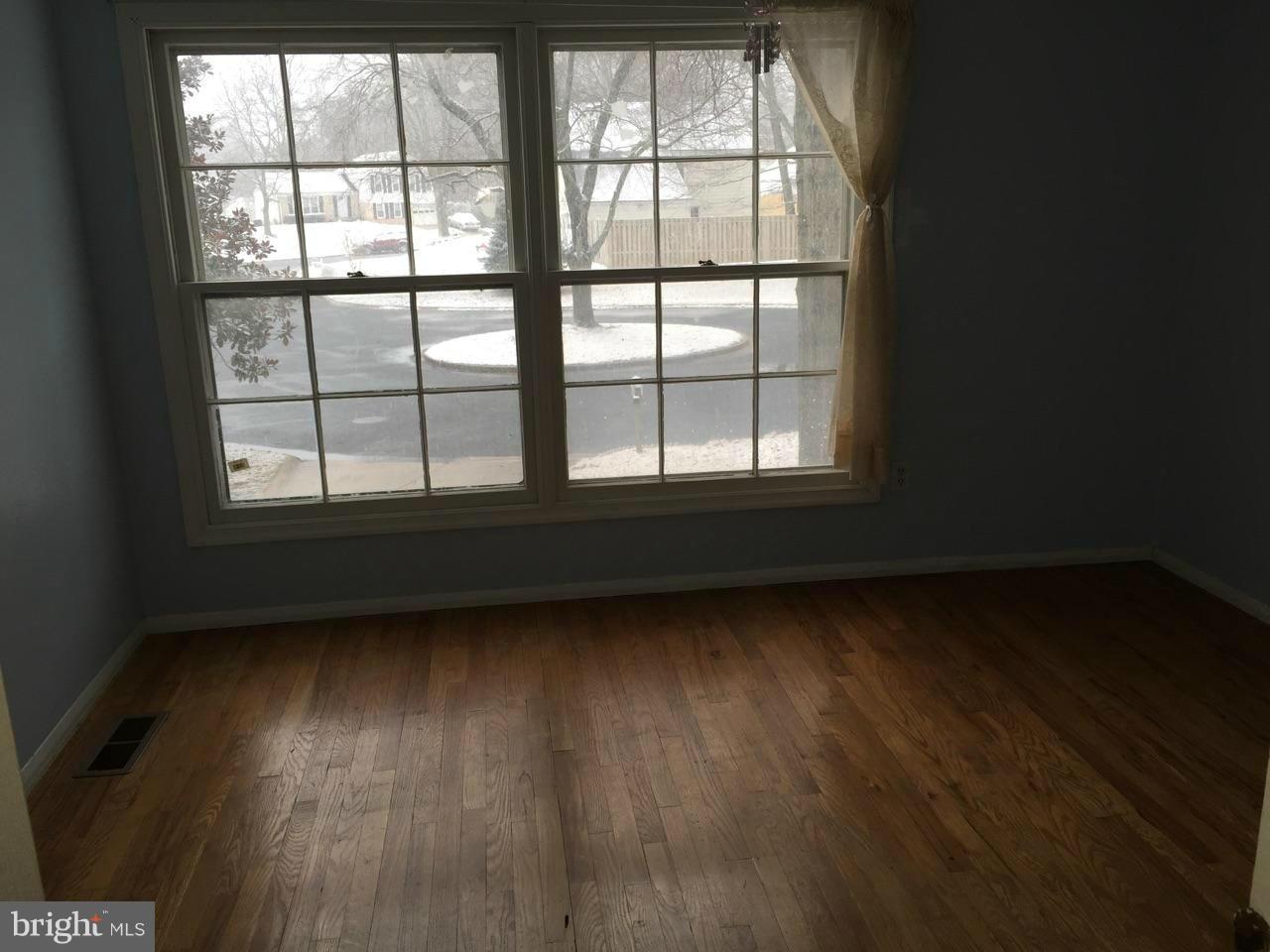 2 Countryside Court Silver Spring, MD 20905 - Photo 6 of 6 a view of an empty room with wooden floor and a window