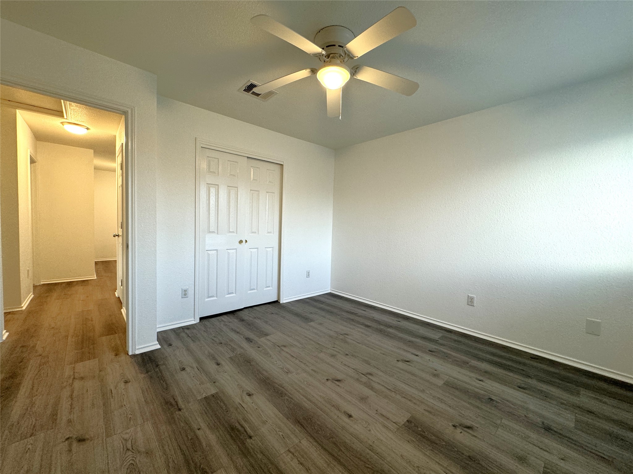 115 Killian Loop Hutto, TX 78634 - Photo 12 of 14 A well-lit bedroom features durable plank flooring and a functional ceiling fan for comfort.