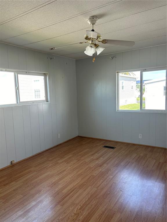12501 Ulmerton Road, Unit 119 Largo, FL 33774 - Photo 12 of 15 an empty room with wooden floor and windows
