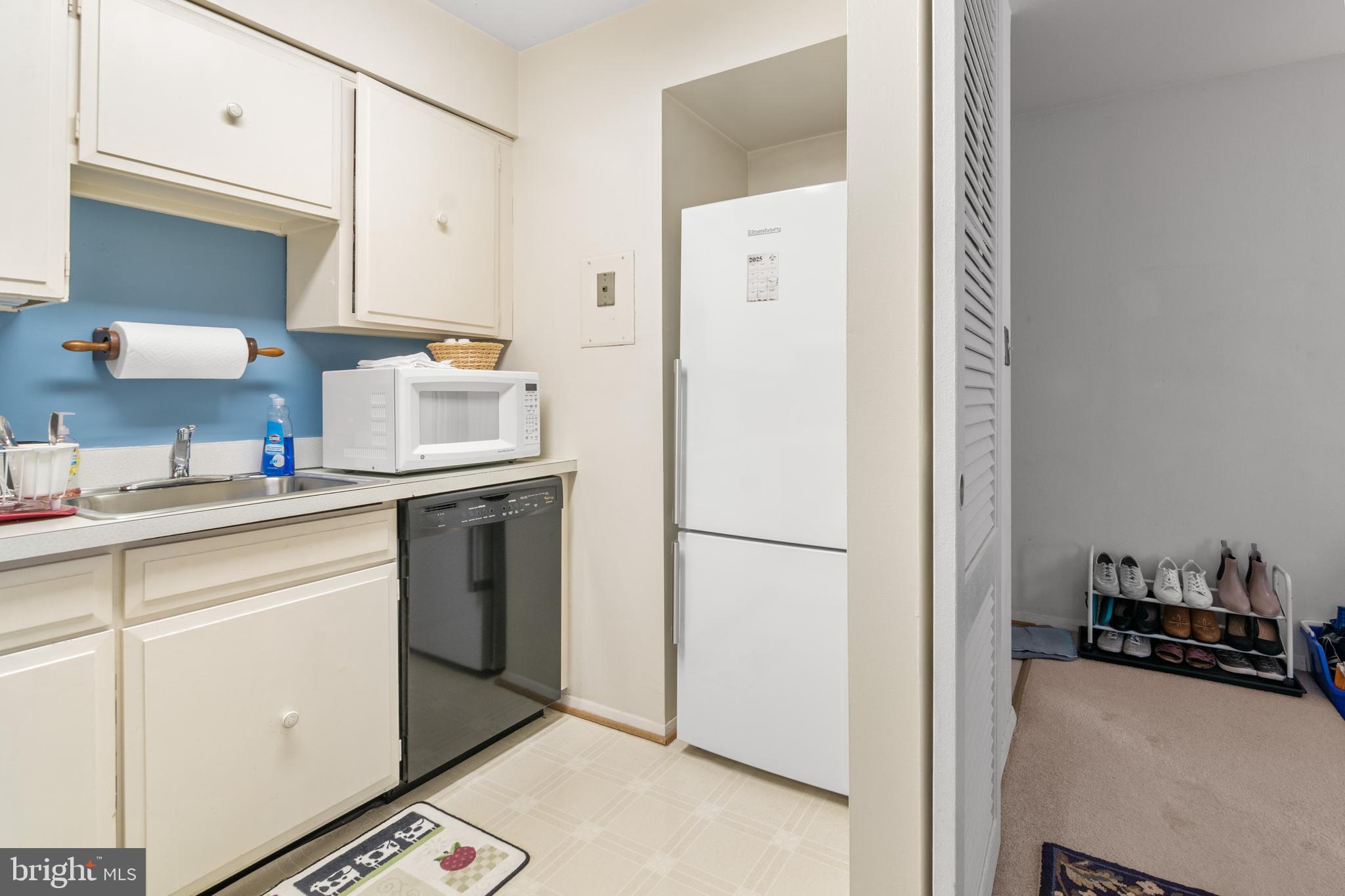 9800 Georgia Avenue, Unit 25301 Silver Spring, MD 20902 - Photo 14 of 22 a kitchen with a refrigerator sink and cabinets