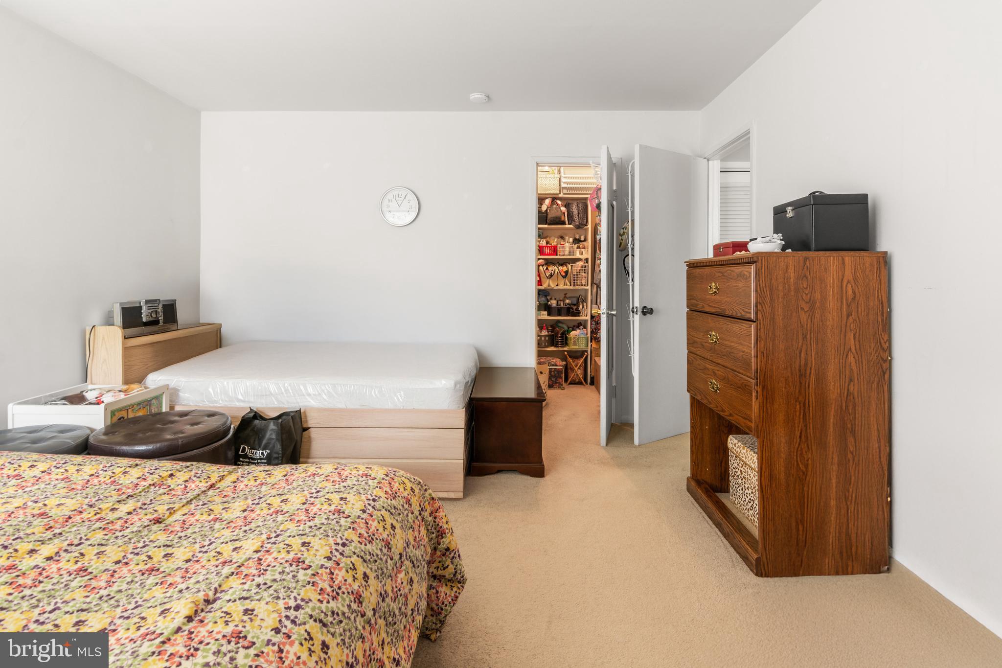 9800 Georgia Avenue, Unit 25301 Silver Spring, MD 20902 - Photo 17 of 22 a bedroom with a bed and a refrigerator