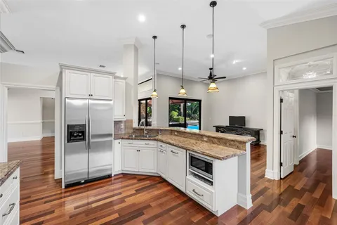a kitchen with a sink a counter top space stainless steel appliances and a ceiling fan