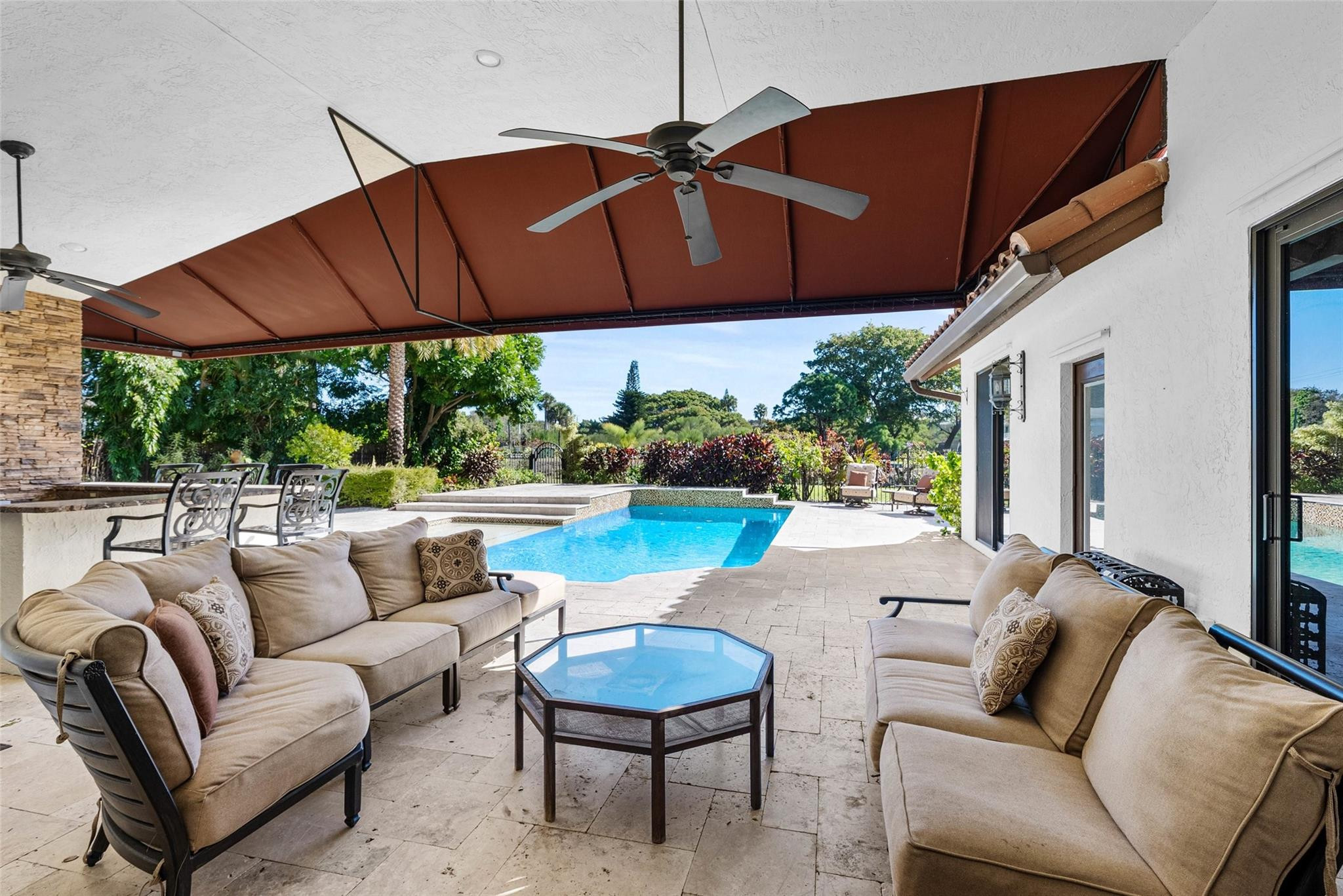 2455 Hampton Bridge Road Delray Beach, FL 33445 - Photo 31 of 46 a view of a patio with couches table and chairs under an umbrella