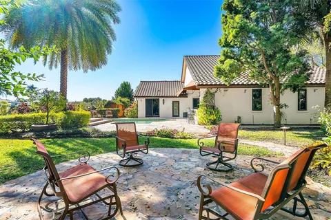 a view of a patio with table and chairs under an umbrella