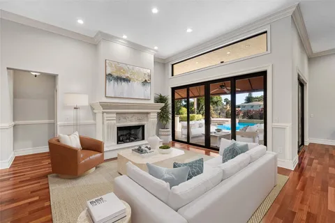 a living room with furniture large window and fireplace