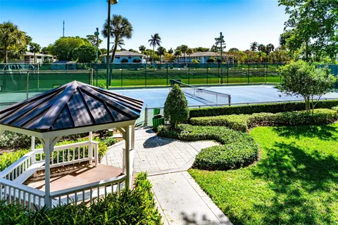 a view of a swimming pool and lounge chairs in back yard of the house