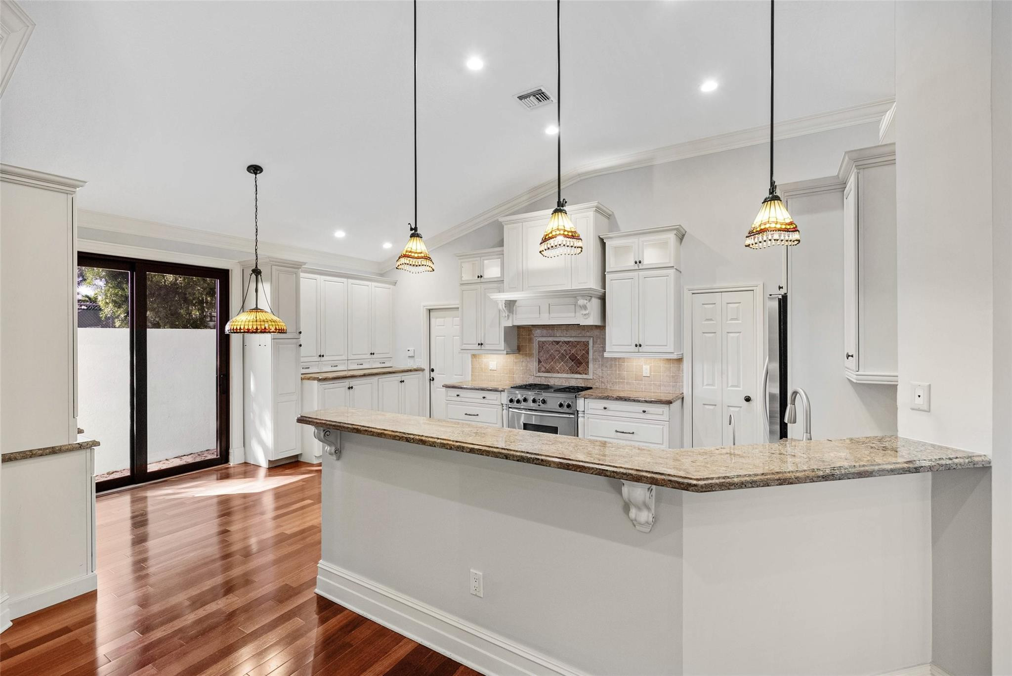2455 Hampton Bridge Road Delray Beach, FL 33445 - Photo 10 of 46 a large kitchen with kitchen island white cabinets and wooden floor
