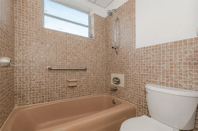 a bathroom with a toilet and bathtub