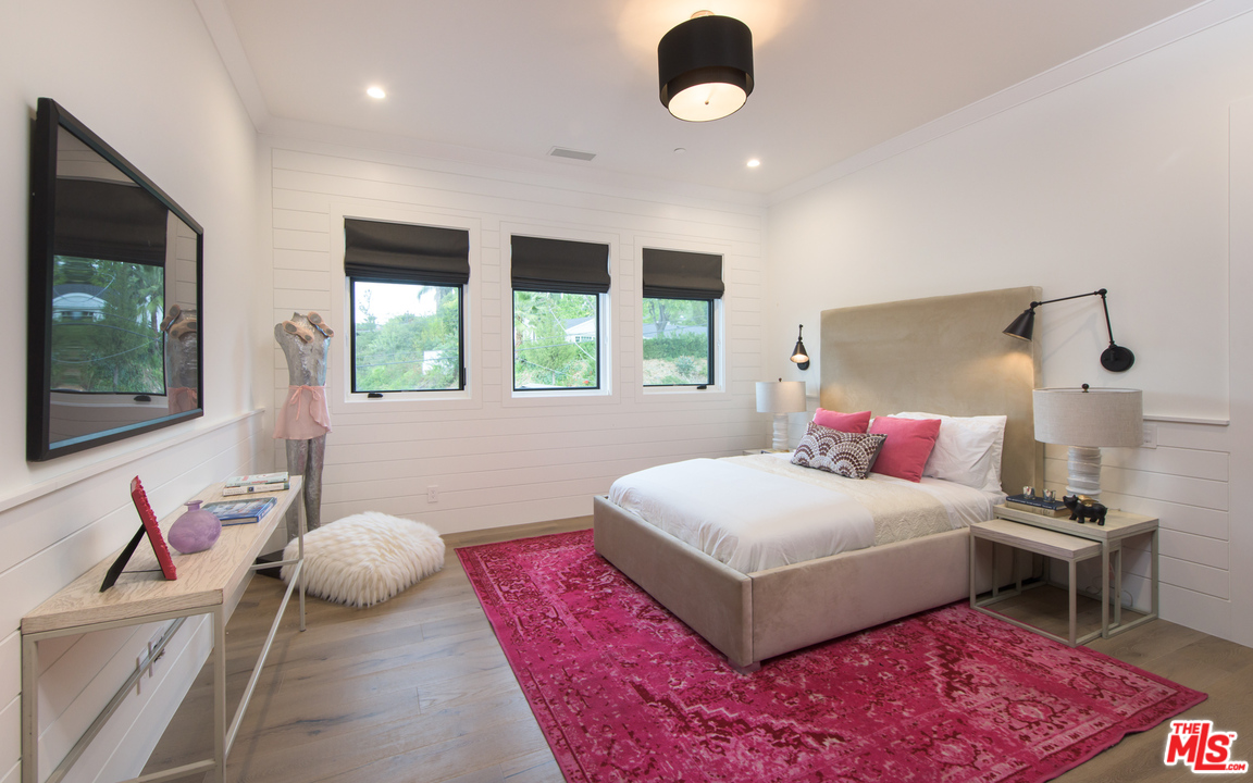 16656 Oldham Street Encino, CA 91436 - Photo 31 of 46 a bedroom with a large bed and a flat tv screen on dresser