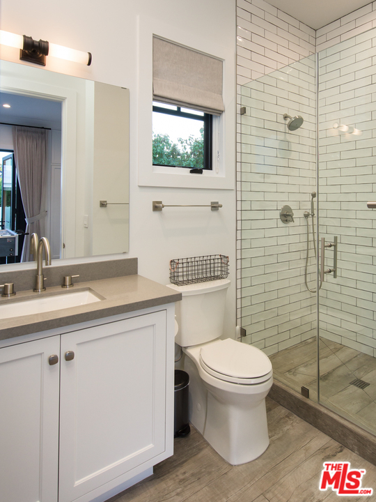 16656 Oldham Street Encino, CA 91436 - Photo 40 of 46 a bathroom with a toilet a sink and mirror