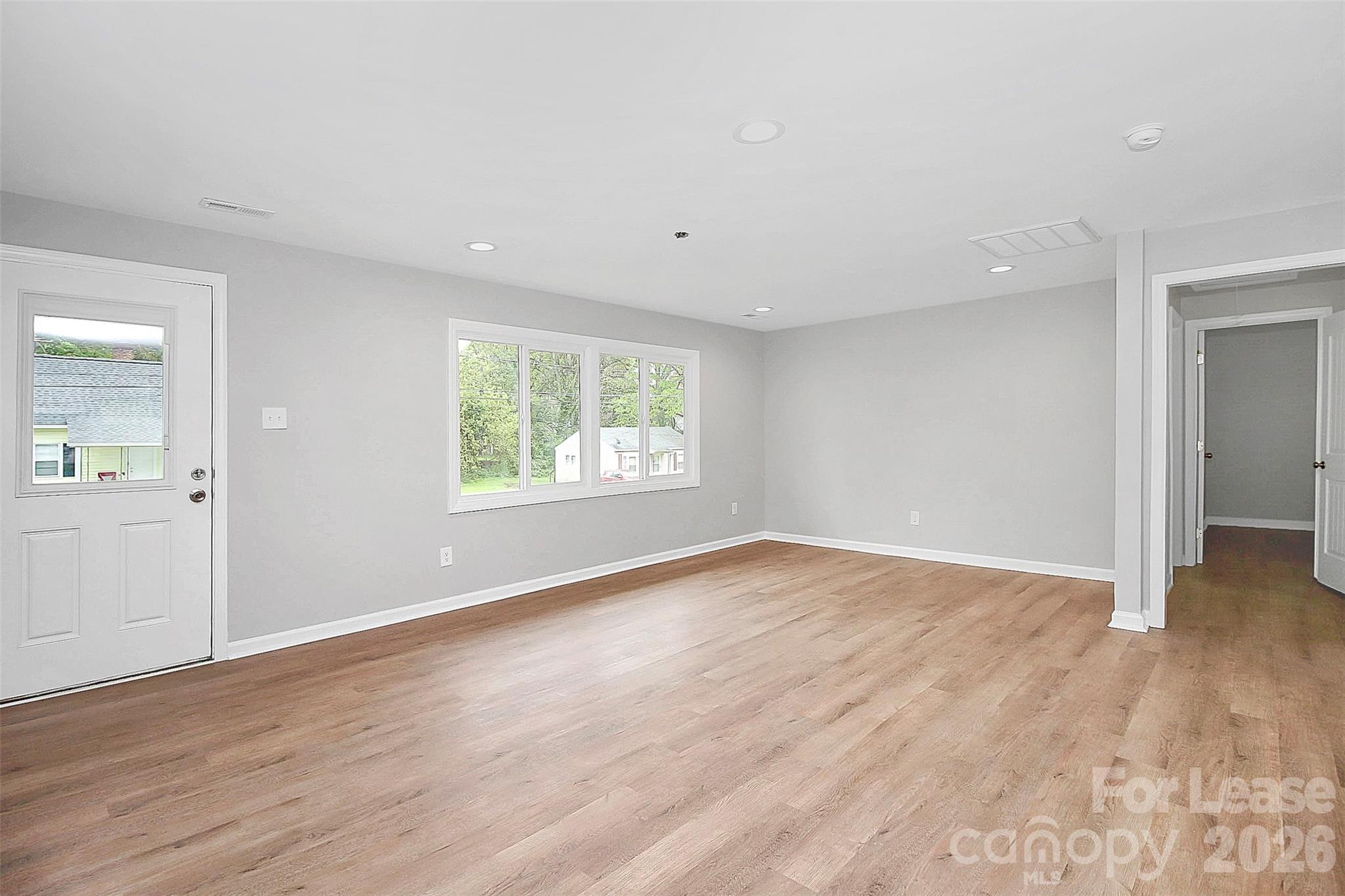 315 South Ransom Street Gastonia, NC 28052 - Photo 11 of 18 a view of an empty room with wooden floor and a window