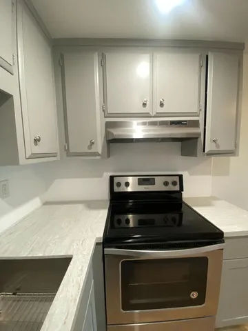a kitchen with a refrigerator a stove top oven a sink and cabinets