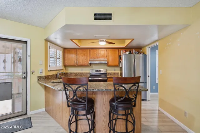 a kitchen with stainless steel appliances a table and chairs