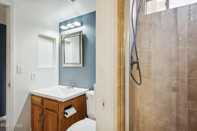 a bathroom with a sink a toilet and shower