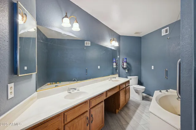 a spacious bathroom with a double vanity sink mirror and bathtub