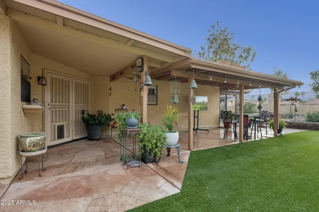 a view of a porch with chairs and potted plants