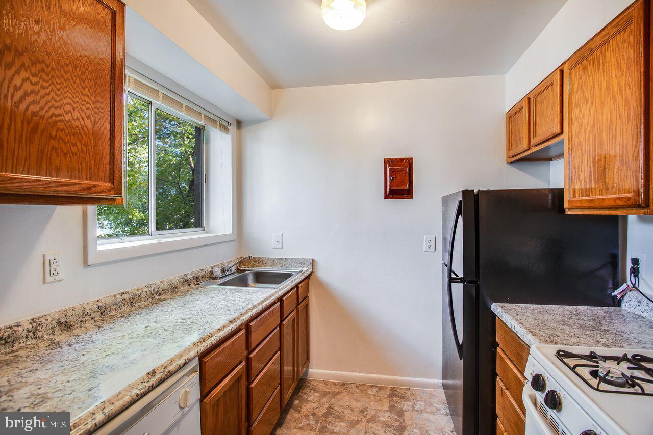 5000 A Street Southeast, Unit 101 Washington, DC 20019 - Photo 11 of 11 a kitchen with granite countertop a refrigerator stove and sink
