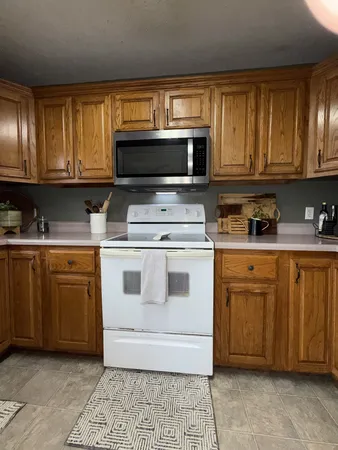 a kitchen with cabinets stainless steel appliances and a window