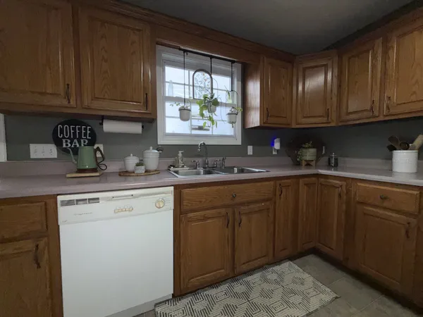a kitchen with granite countertop wooden cabinets stainless steel appliances a sink and window