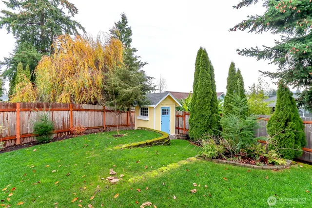 a view of a backyard with potted plants and wooden fence