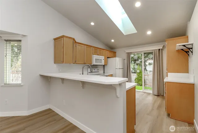 a kitchen with stainless steel appliances granite countertop a sink a stove and a wooden floors