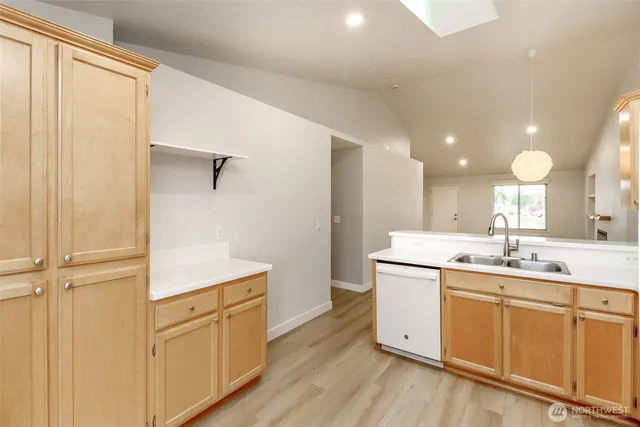 a kitchen with a sink cabinets stainless steel appliances and a window