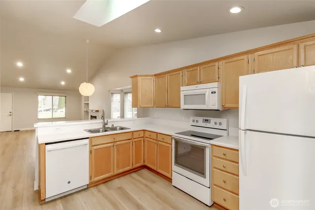 a kitchen with a sink a refrigerator and cabinets