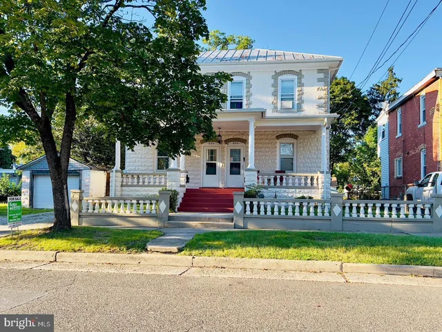 a view of a house with a yard and large tree