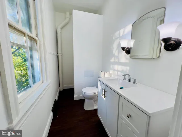 a bathroom with a toilet sink and mirror