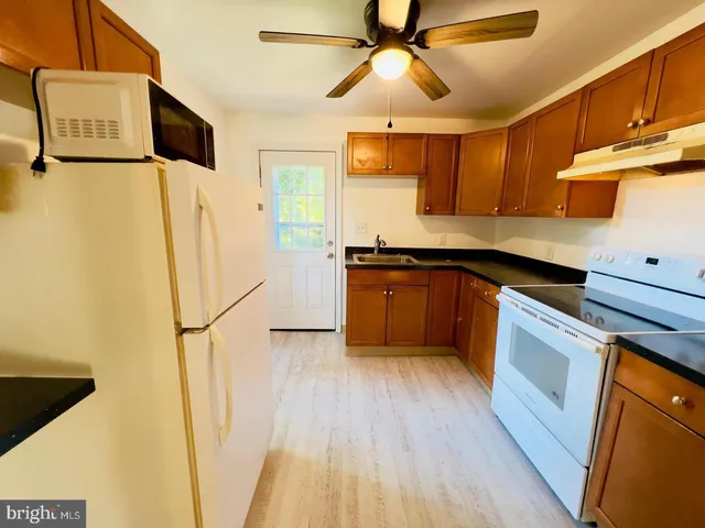 a kitchen with stainless steel appliances a refrigerator a sink a stove top oven a counter space and cabinets