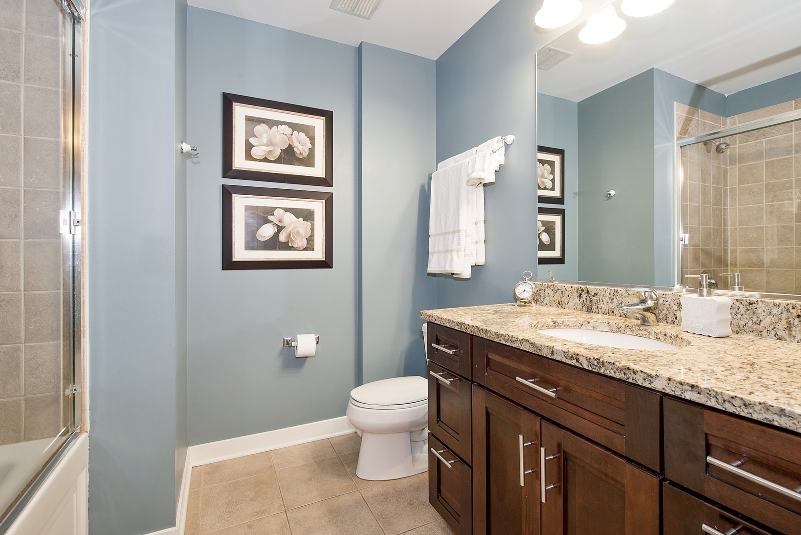 920 West Madison Street, Unit 6C Chicago, IL 60607 - Photo 8 of 10 a bathroom with a granite countertop toilet a sink and a mirror