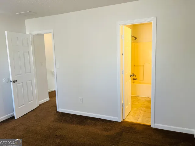 a view of a room with a bed and wooden floor