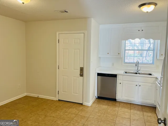 a view of a kitchen with white cabinets