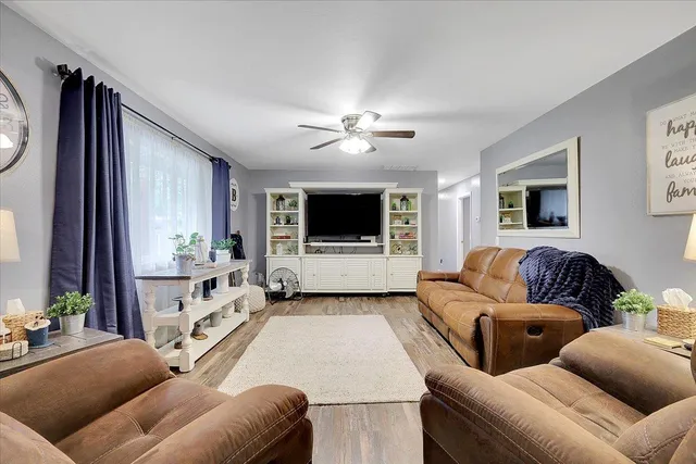a living room with furniture a ceiling fan and a rug