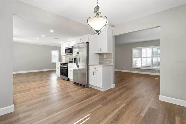 a view of kitchen with wooden floor and electronic appliances