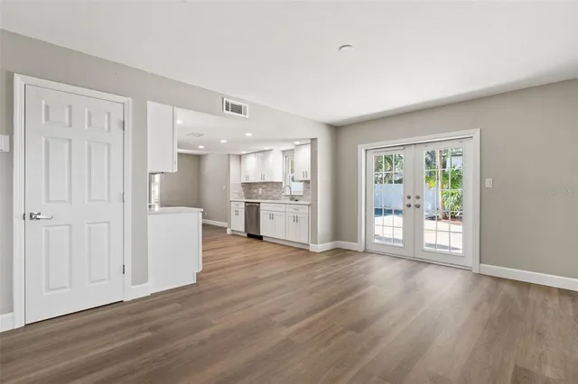 a view of a kitchen with wooden floor and a window